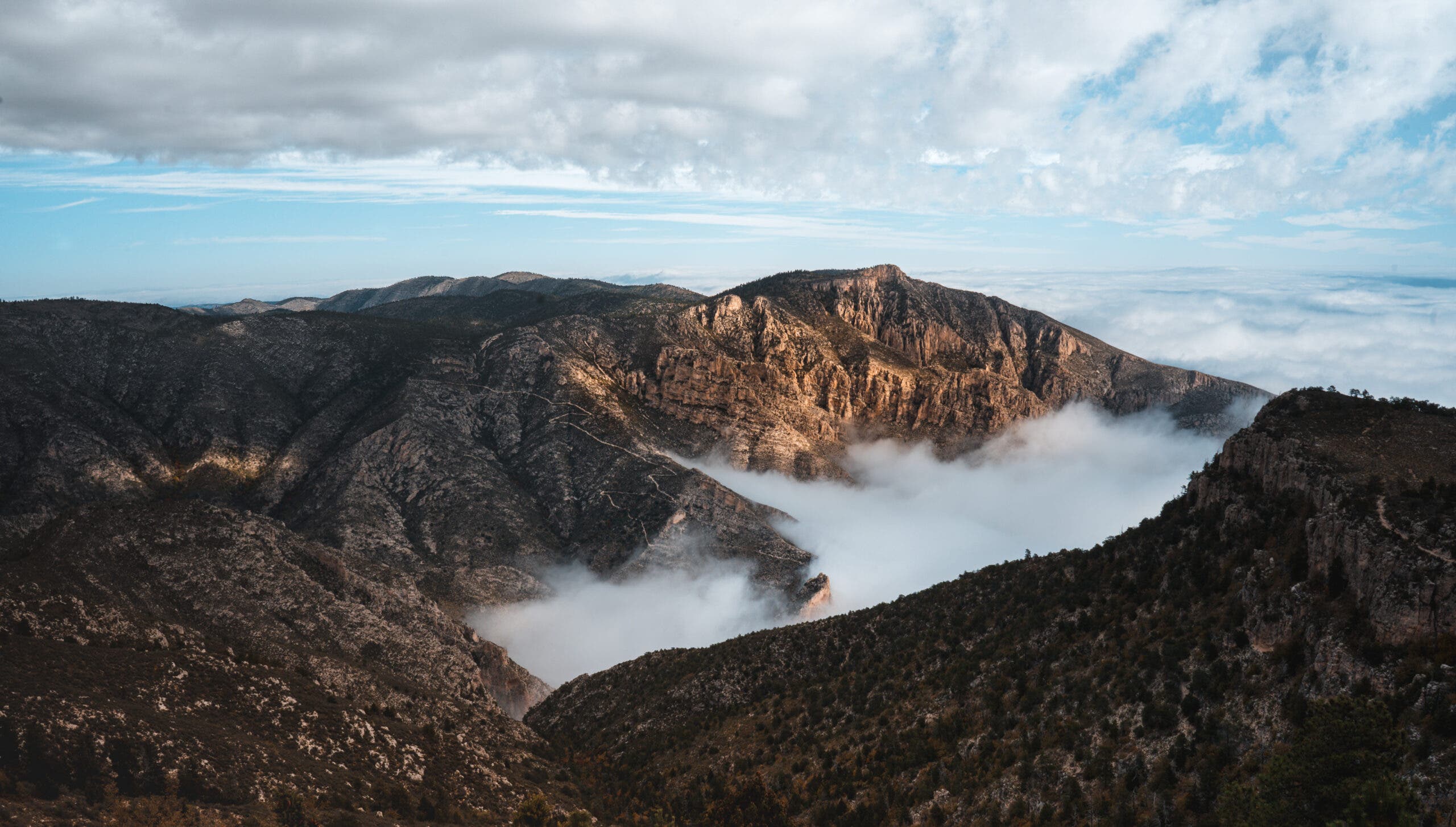 A view of the Guadalupe Mountains with clouds above and below the this amazing sunrise hike trail. 