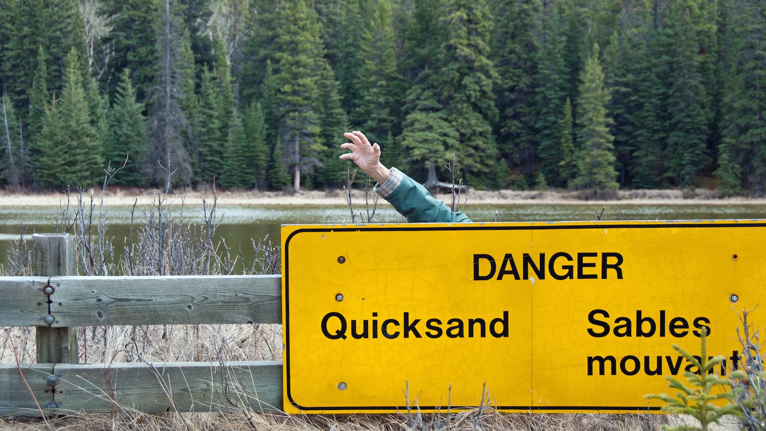 man sinking in quicksand behind sign