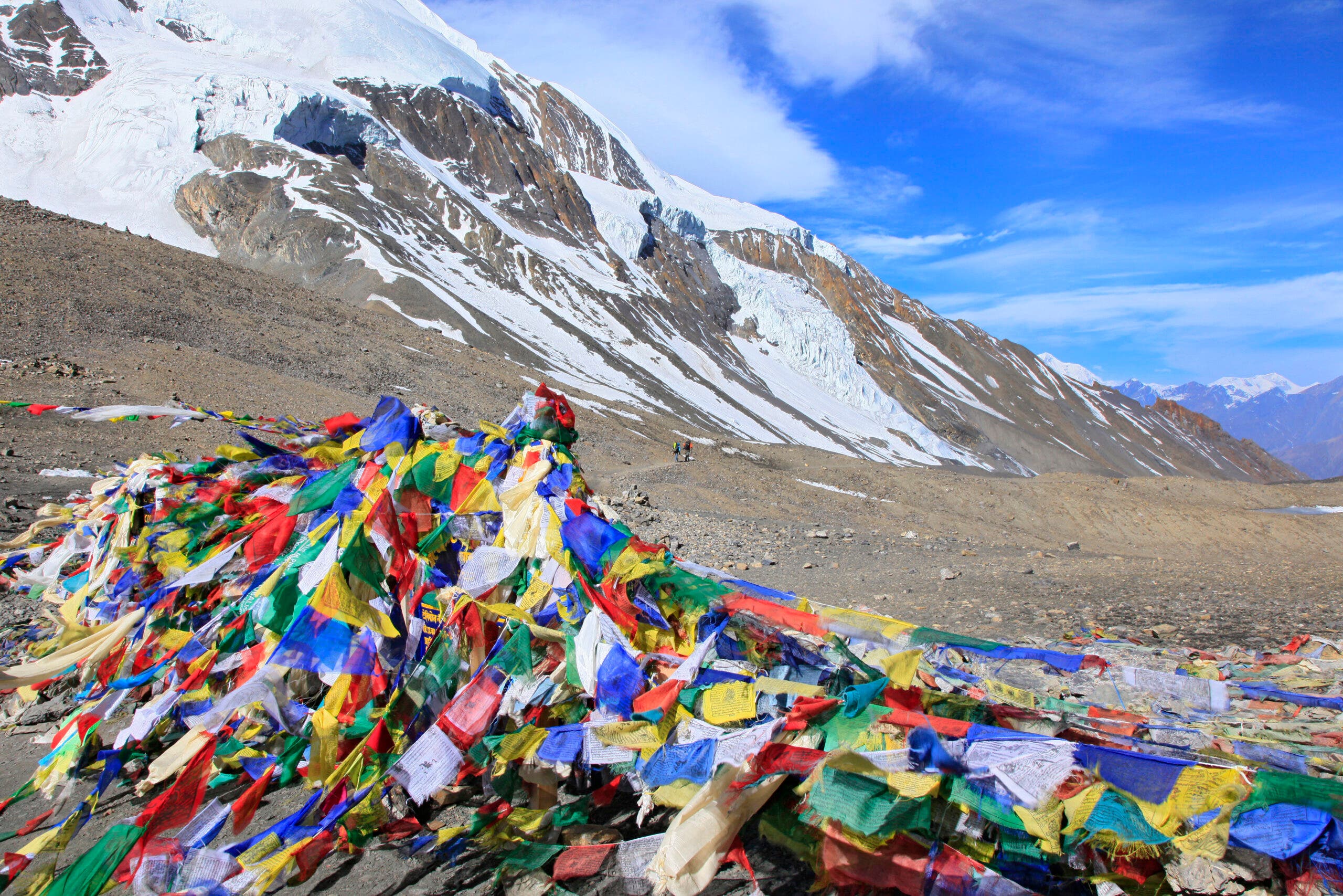 Thorung La Pass, elevation 5416 meters, covered in Buddhist prayer flags, one of the highest trekking passes in the world, along Annapurna Circuit trek, Nepal.