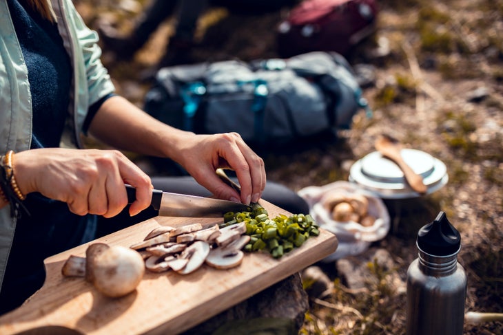 chopping fresh vegetables at campsite