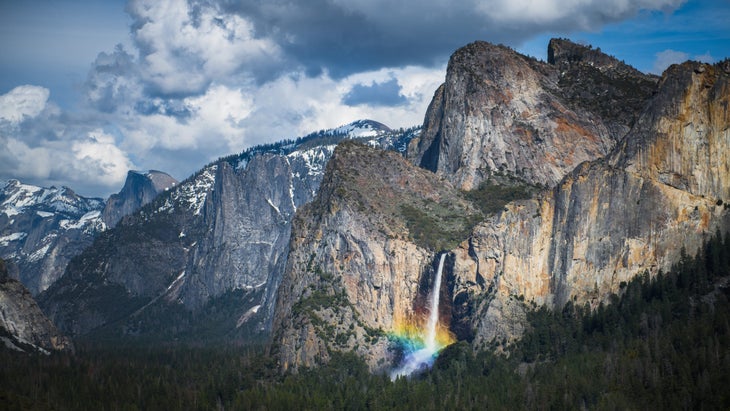 A rainbow emerges from the mist at the base of Bridal Veil Falls in California's Yosemite National Park.