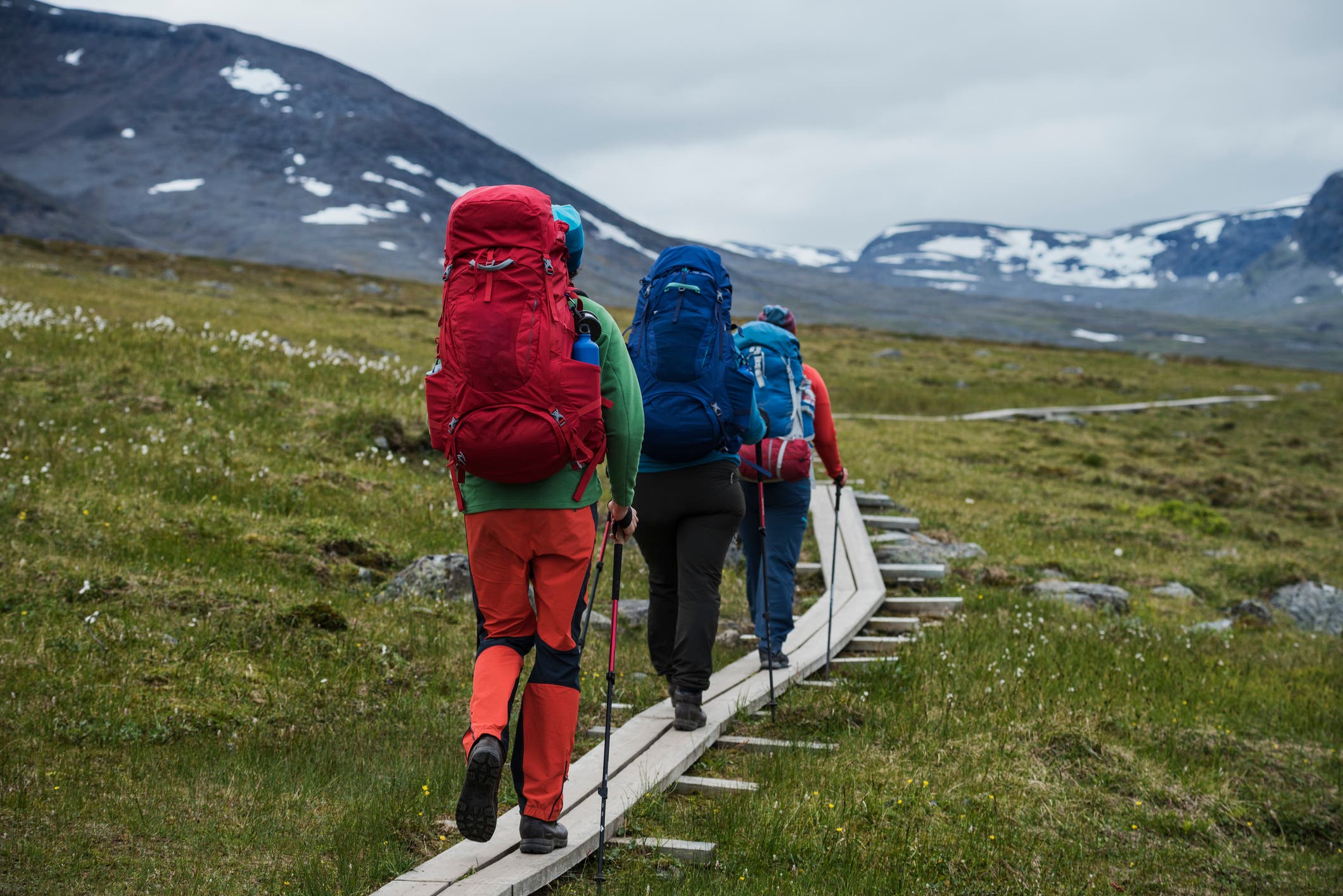 Hikers walking on wooden planks.