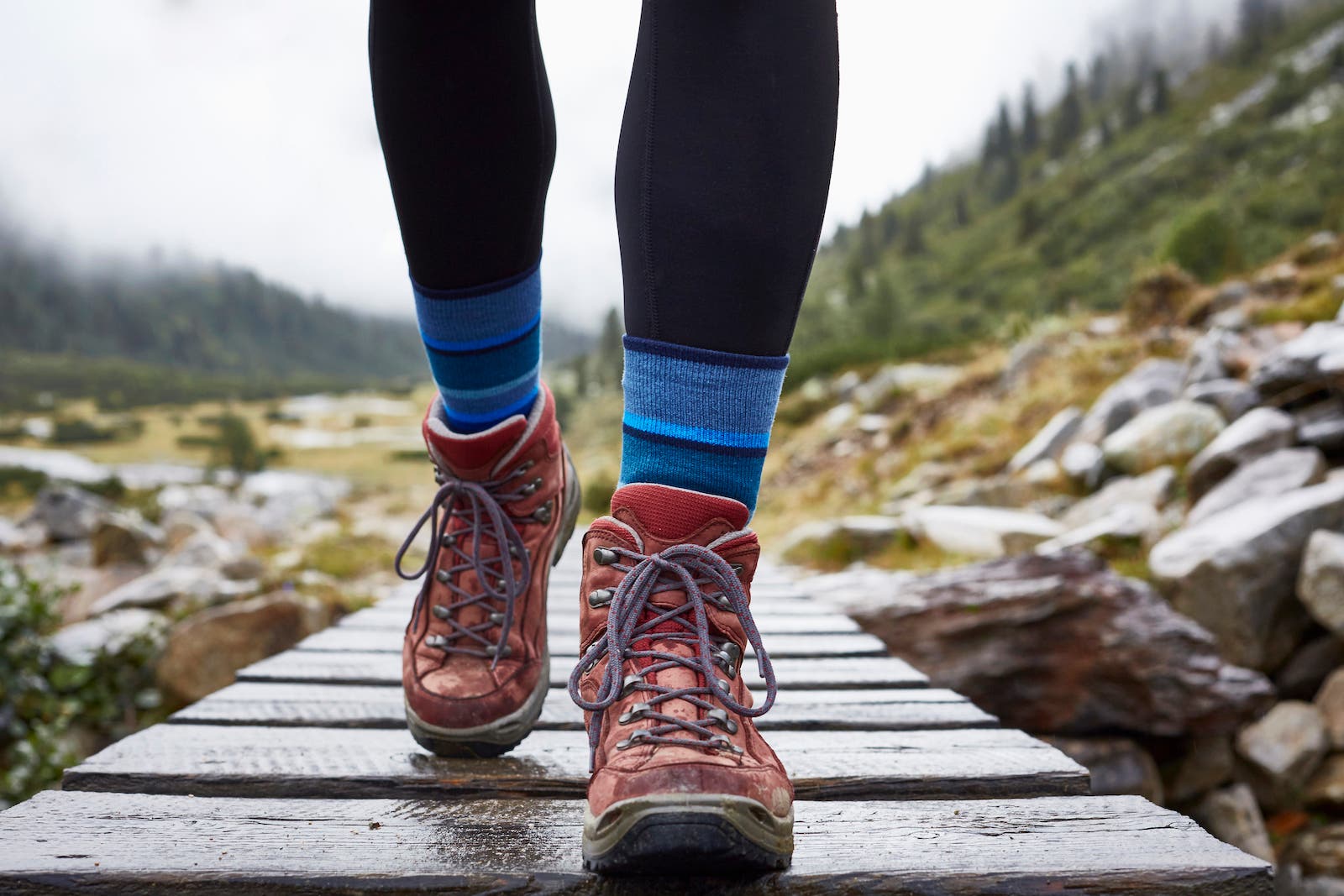 close up of hiking boots walking across bridge