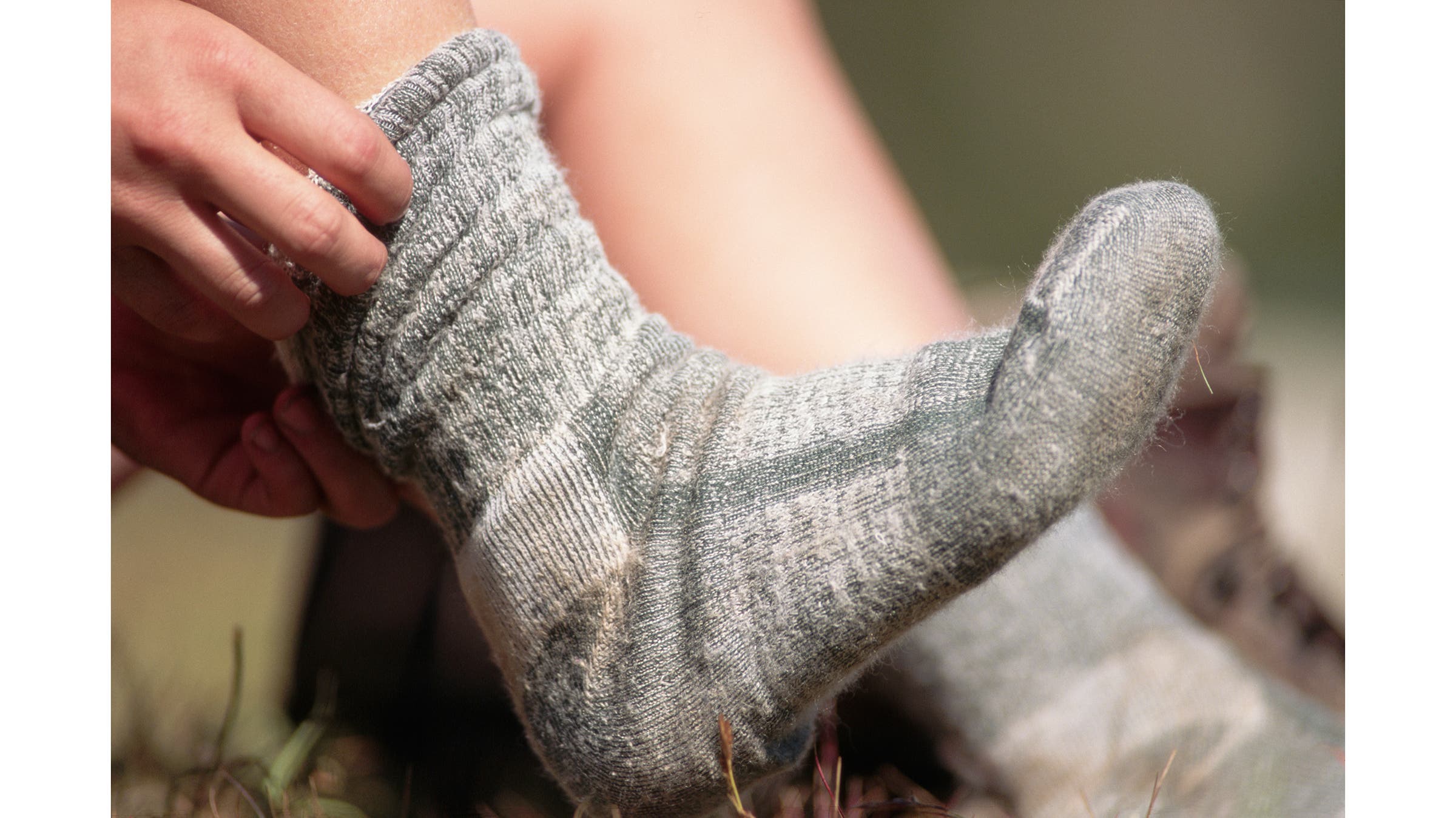 A hiker pulls on heavy socks during a hike in the Wallowa Mountains.