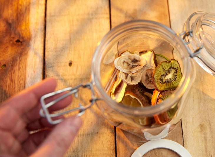 Blood orange, pear, banana, kiwi fruit, Granny Smith apple and lemon chips in opened jar.