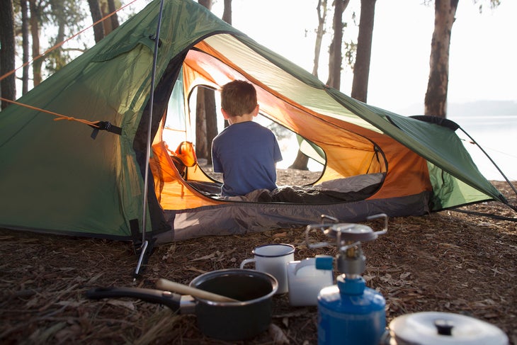 Young boy sitting alone in tent