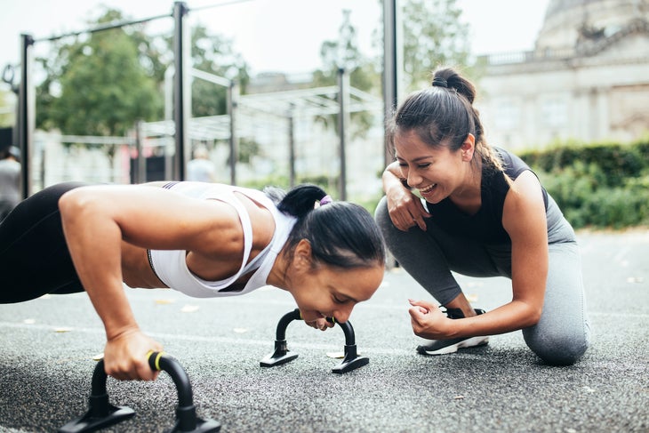 Female coach giving push-up instruction to a woman.