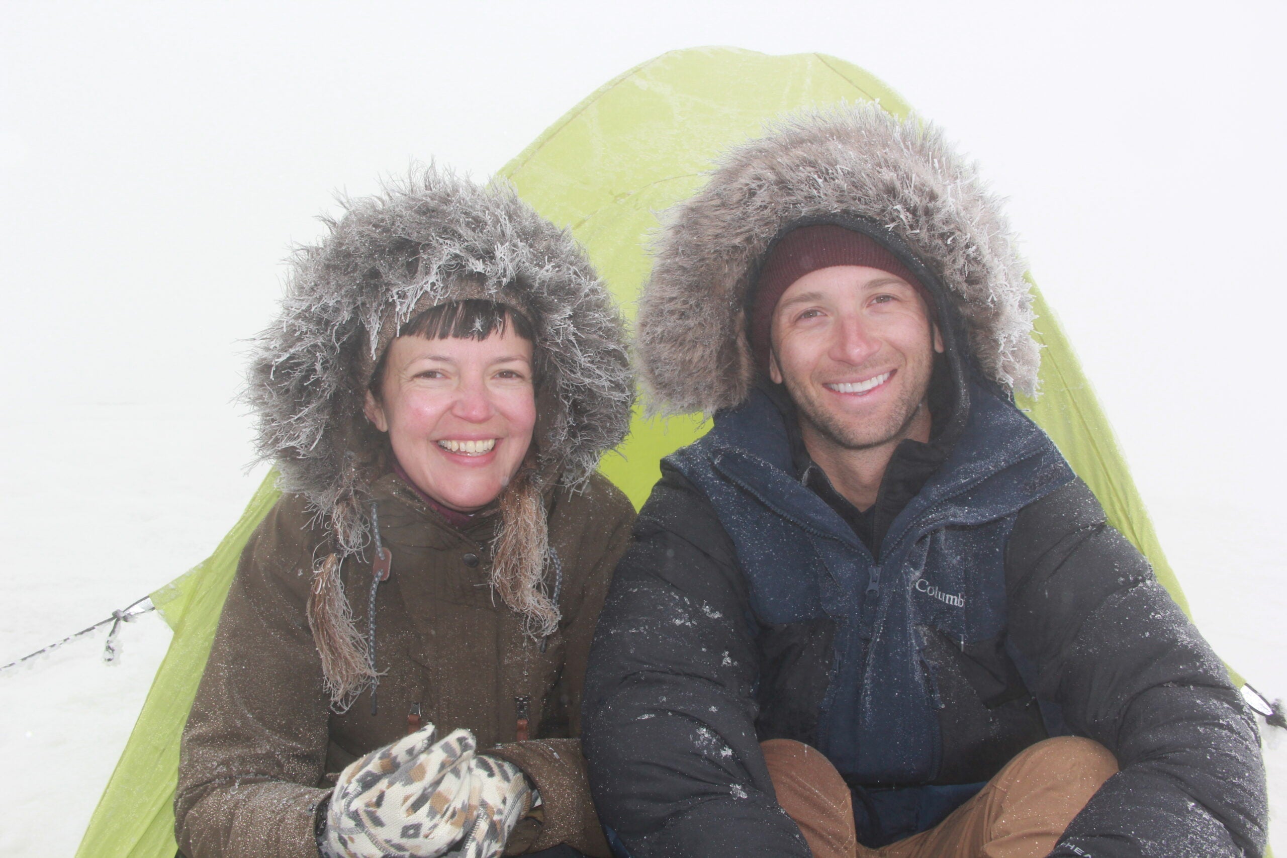 Two winter campers in front of their tent