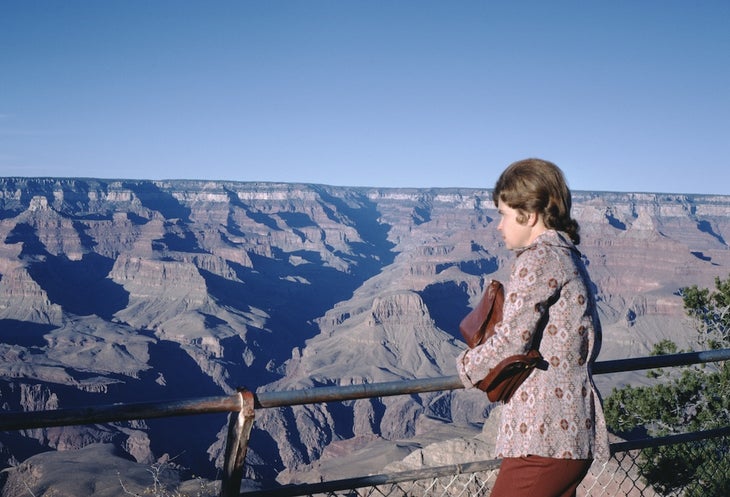 woman in 1974 looking out onto grand canyon, holding purse