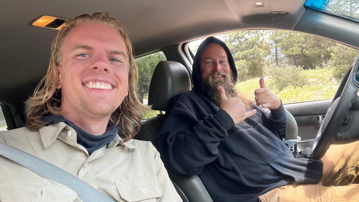 Two people in a car smiling at camera