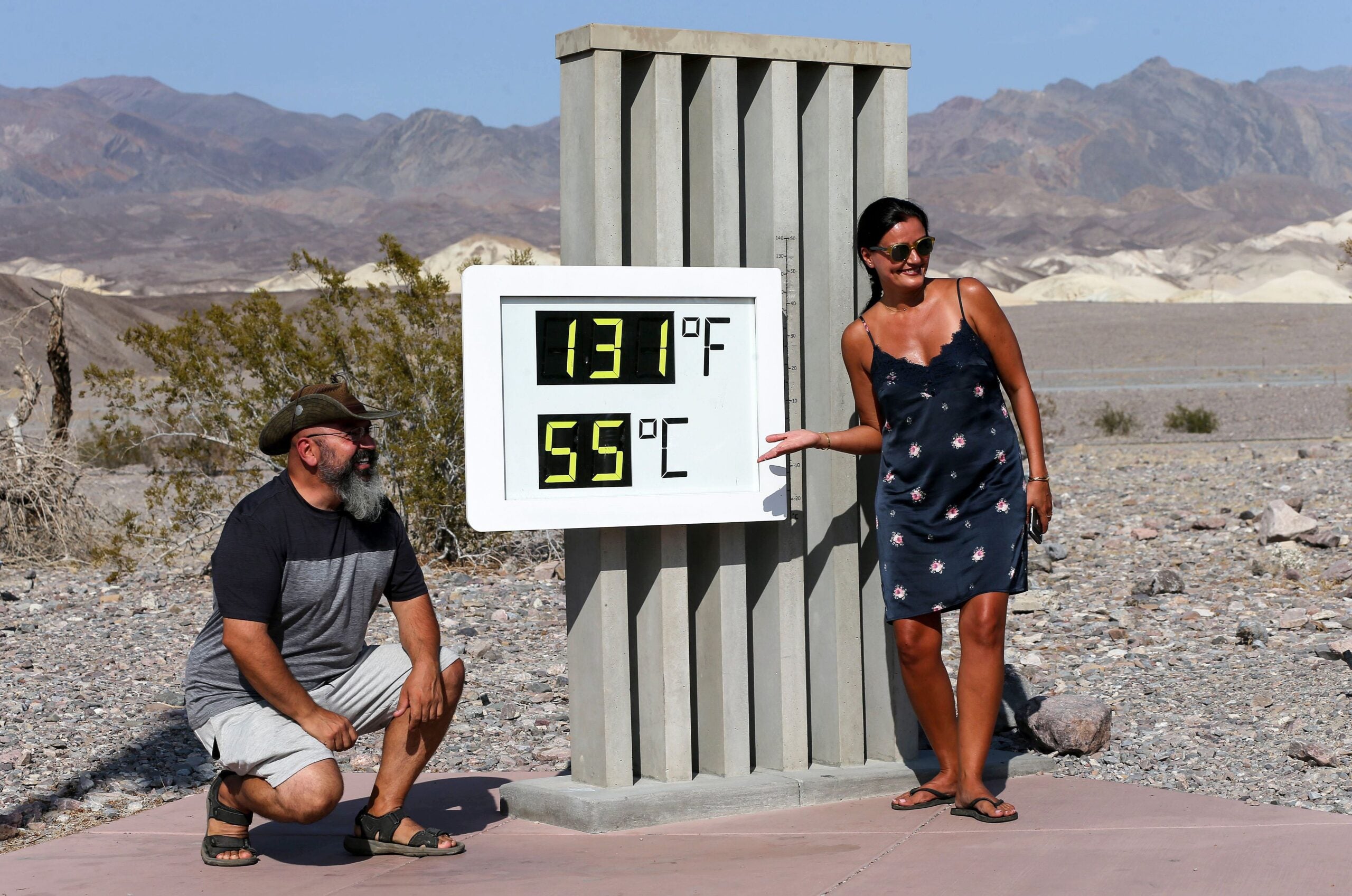 Visitors gather for photo in front of Death Valley National Park's thermometer.