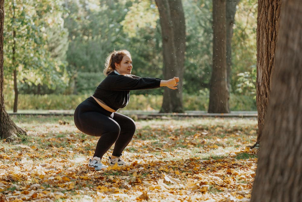 Young woman squatting in park