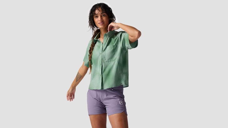 person wearing green mountain bike button-up jersey and purple shorts