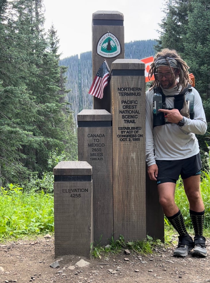 nick fowler posing at the northern terminus of the PCT