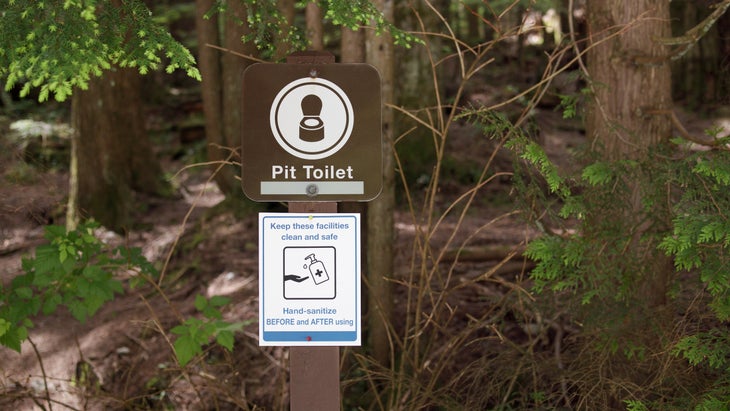 Sign in front of pit toilet