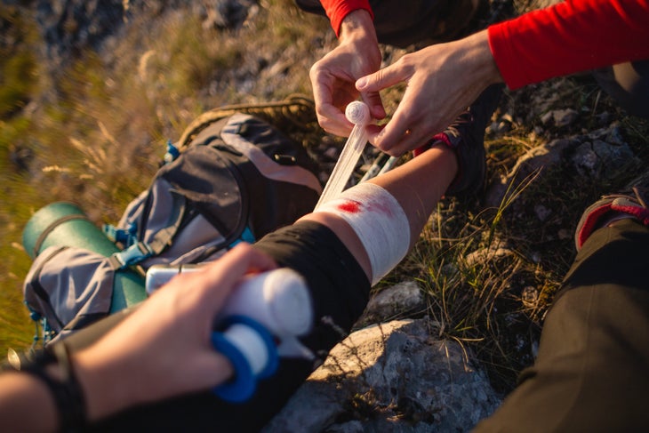 A hiker gets her injured leg wrapped in gauze 