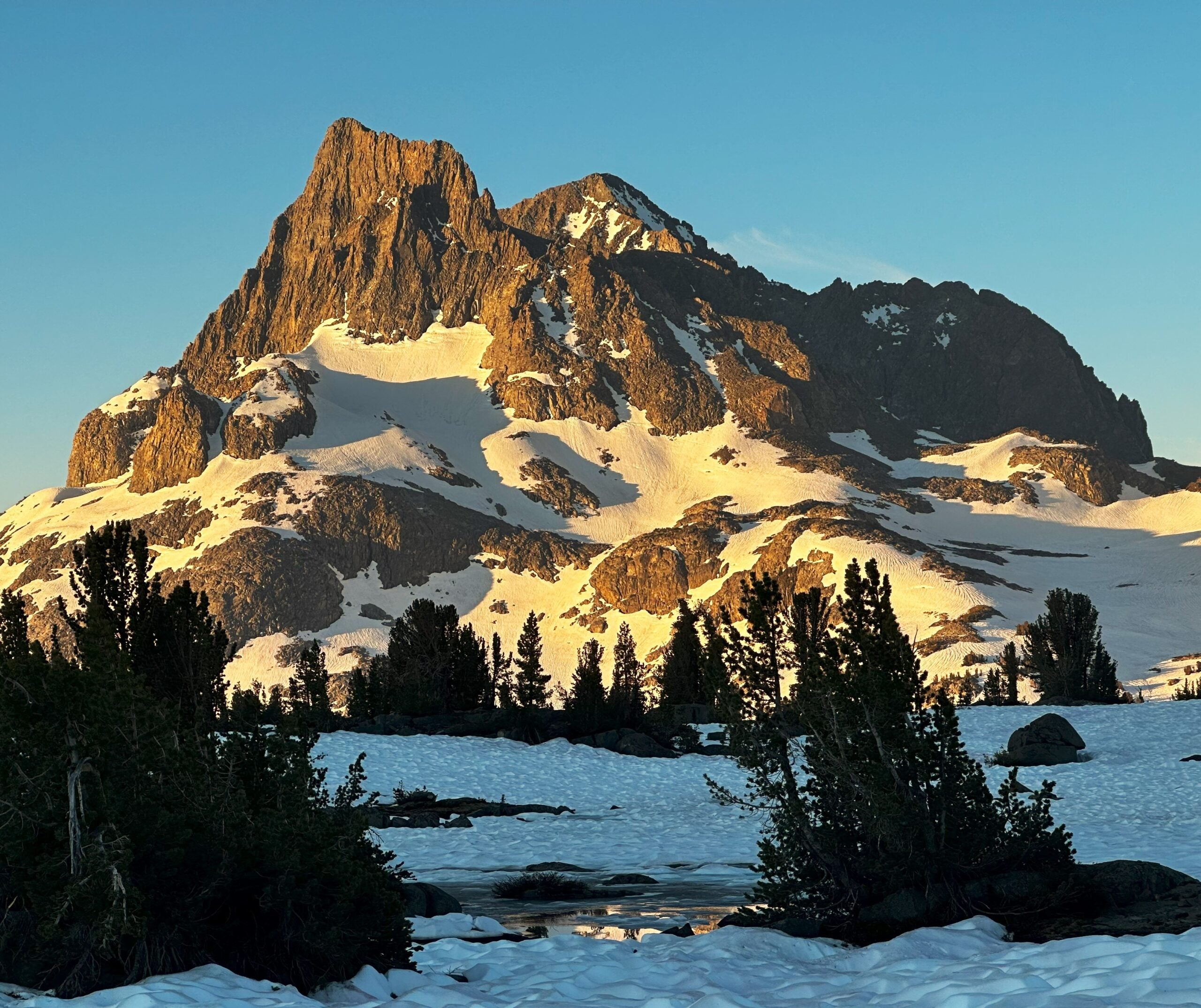 A snowy mountain glowing in the sun