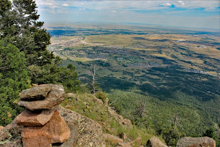 rock cairn with view of expansive valley below