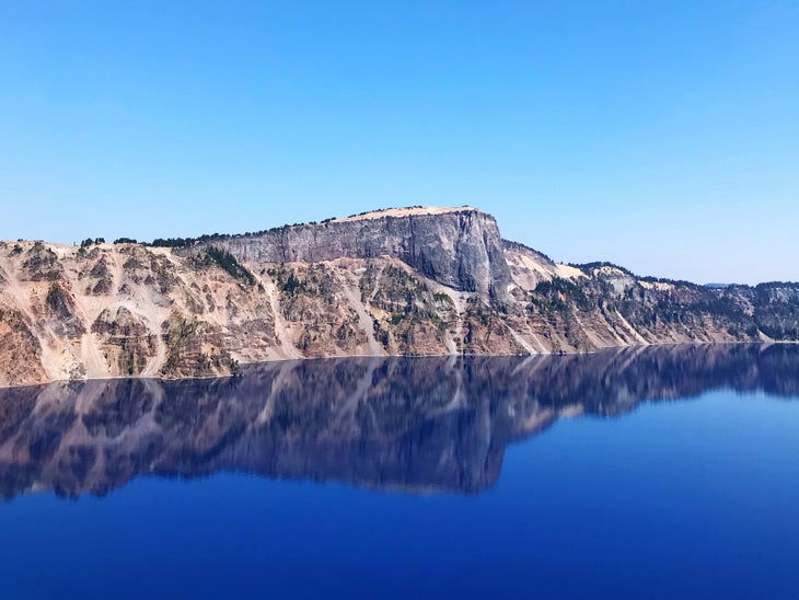Clear blue lake with cliffs rising on the far shore