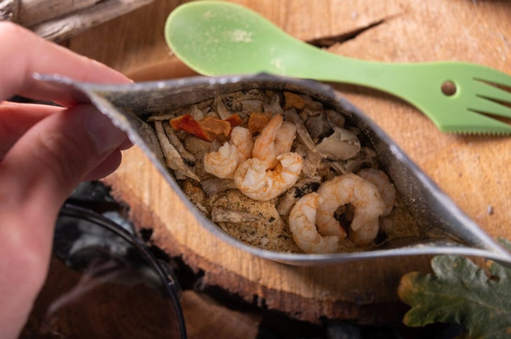 A pouch of freeze-dried shrimp and vegetables with a green spork.