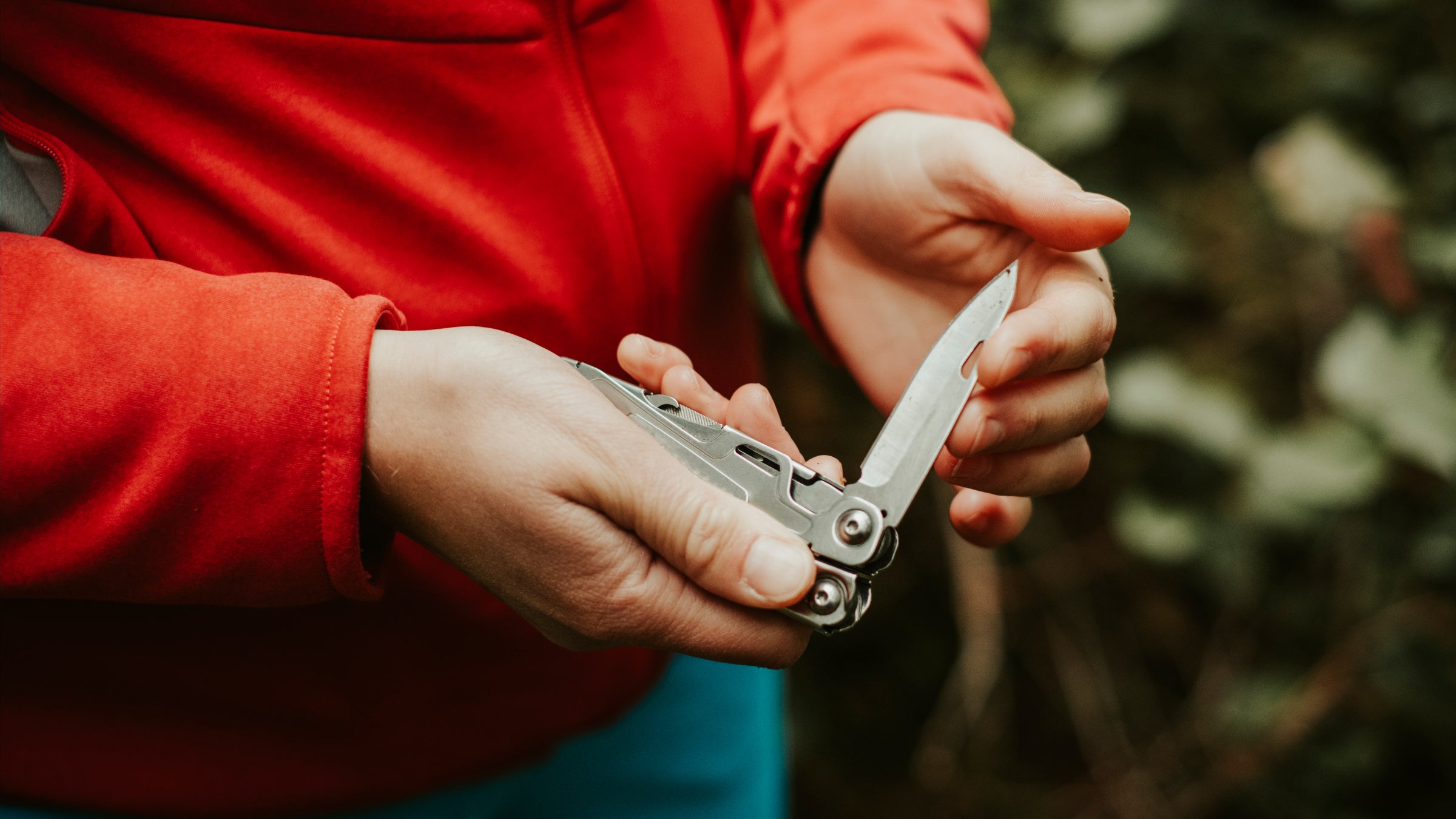 A hiker closes the blade on a pocket knife.
