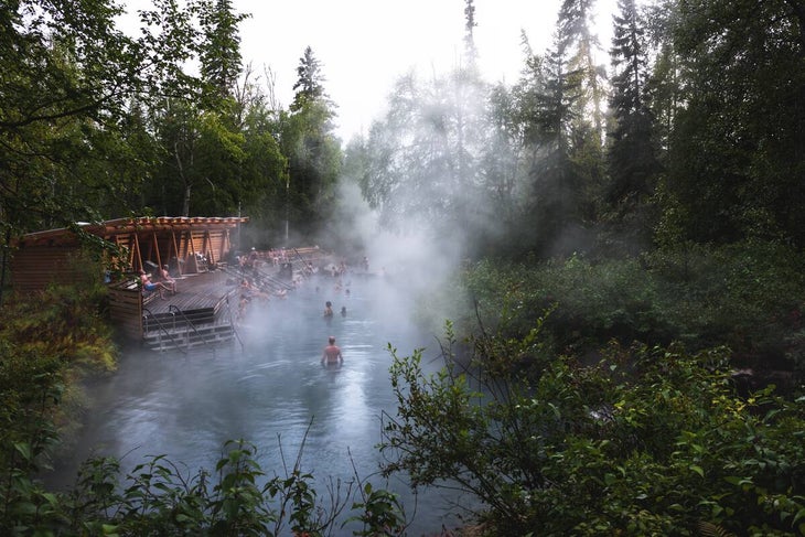 A group of people in the Liard River Hot Springs with steam