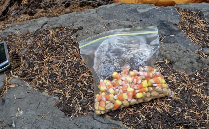 a bag of candy corn and peanuts on a rock while hiking