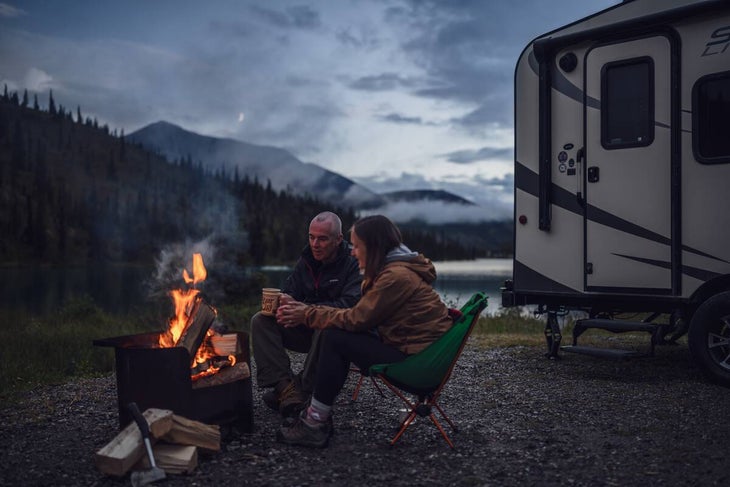 A couple enjoys the warmth of a campfire at Summit Lake Campground.