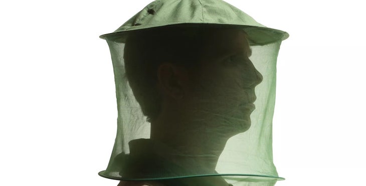 a man wearing a mosquito head net 