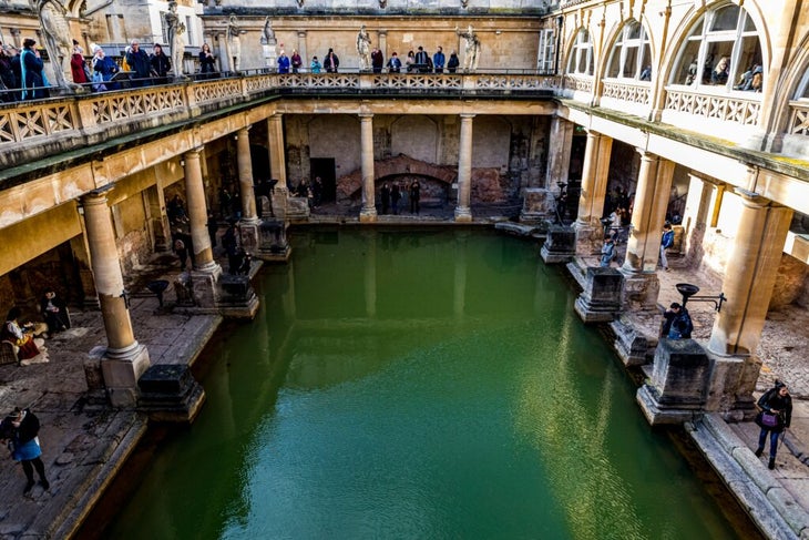 The center of the hot springs complex in Bath surrounded by tourists on a sunny day 