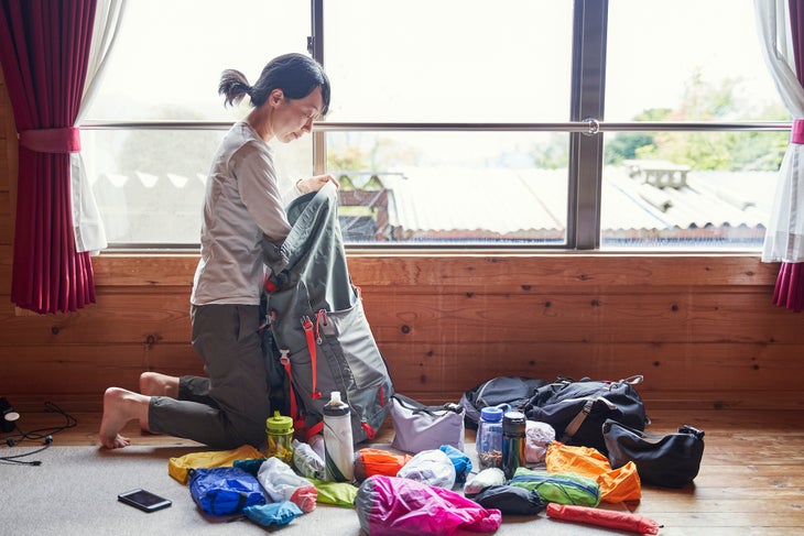 woman packing backpack inside
