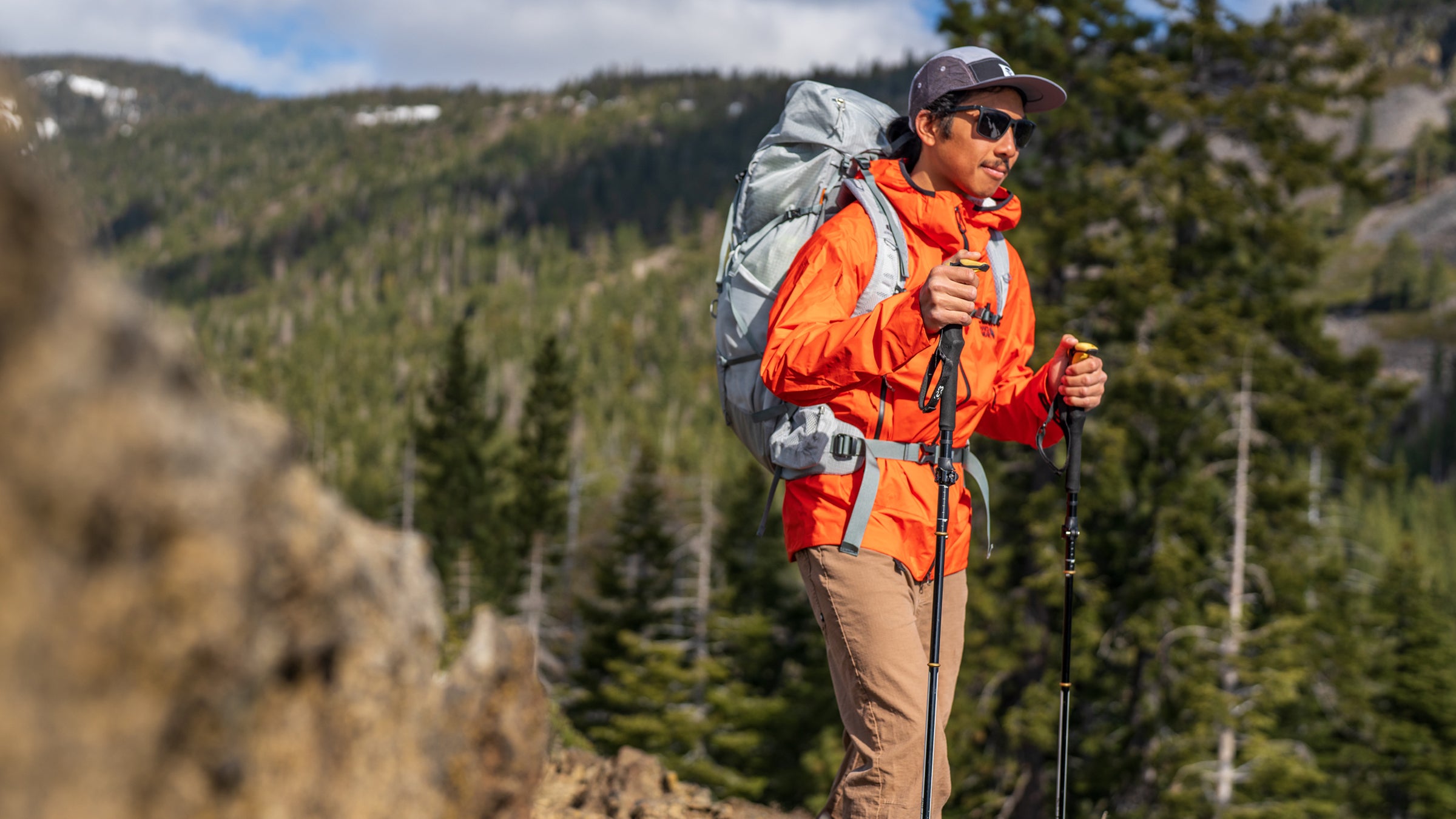 hiker with a rain jacket on the best men's rain jackets 2025