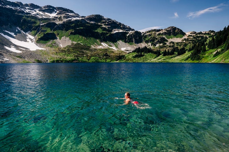 A woman swims through the cold waters of a lake heat stroke