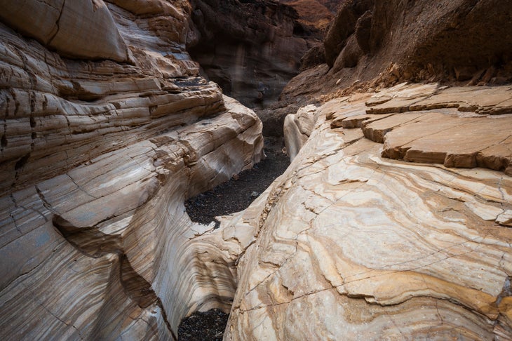 An asphalt trail leads through the smooth white polished marble walls in Mosaic Canyon. Death Valley National Park