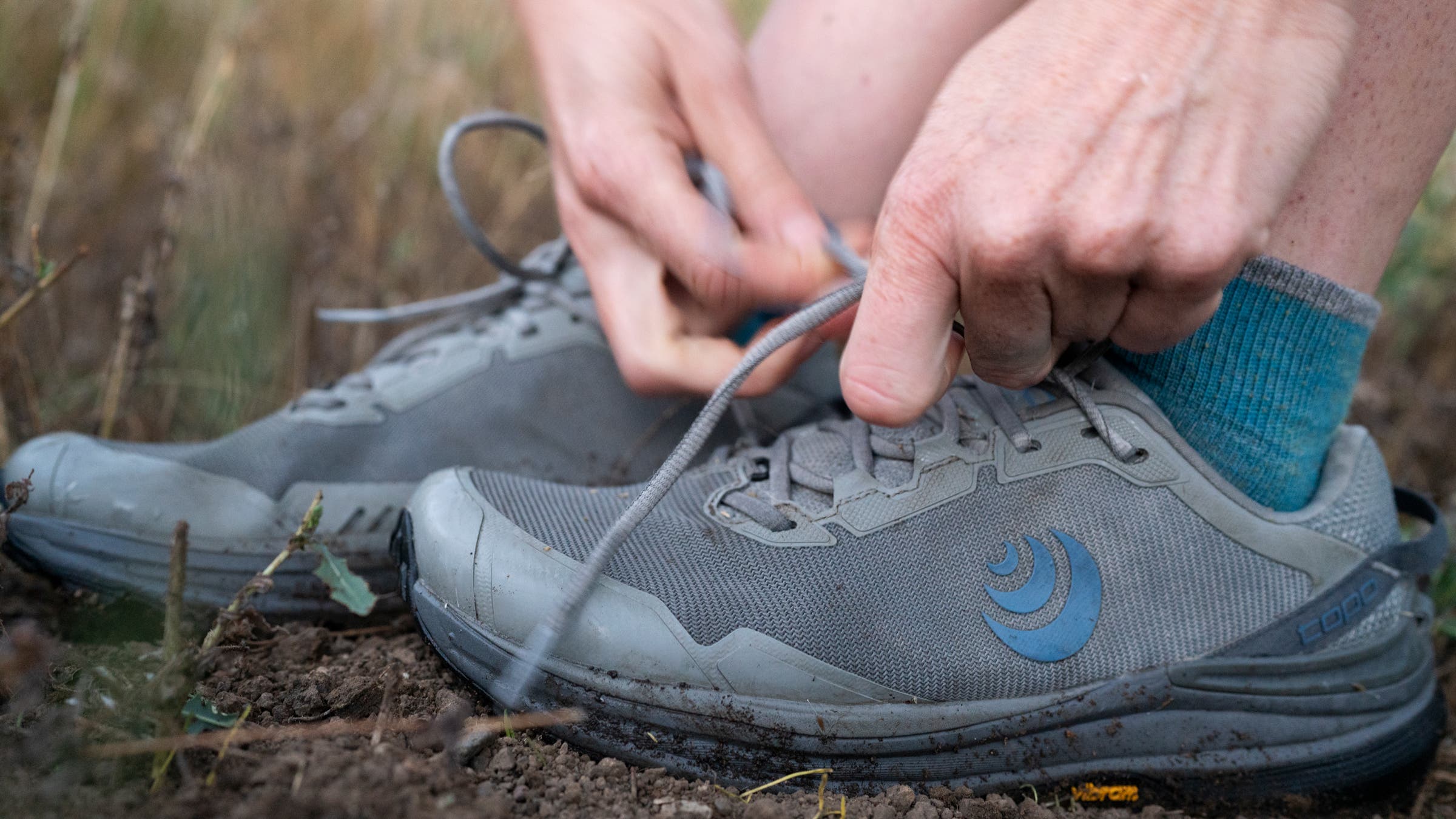 Topo Traverse grey and blue hiking shoe laces tying on trail