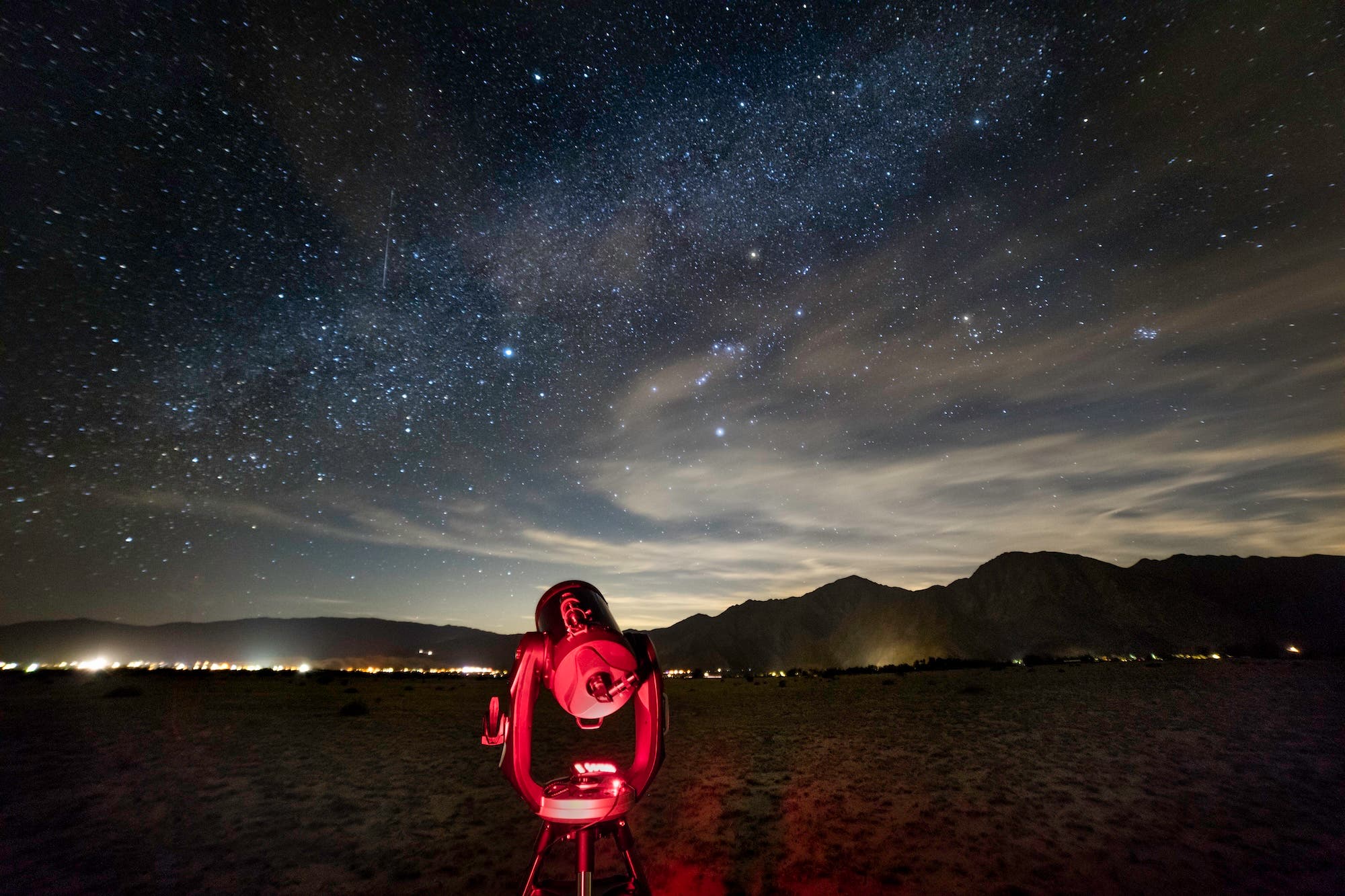 An 11" catadioptric (Schmidt–Cassegrain) telescope is illuminated red by an astronomer's flashlight under a starry desert sky near the village of Borrego Springs