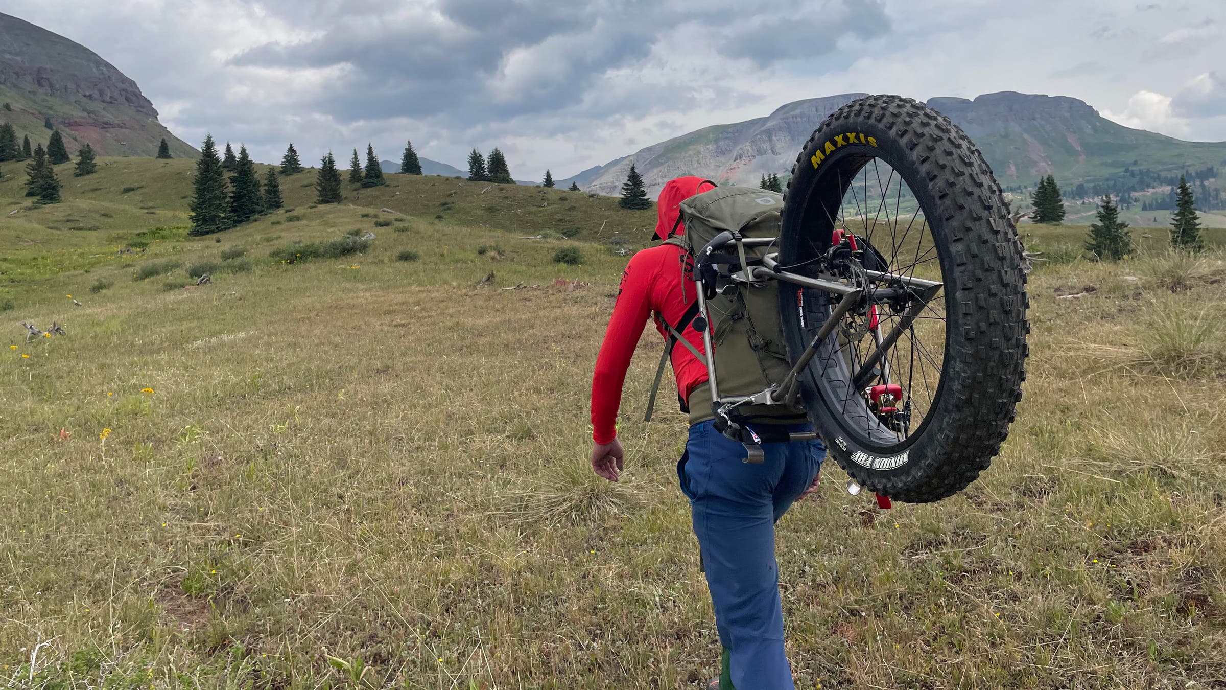 Fjällräven Kajka X-Latt 45 carrying fat tire biking tire in backcountry.