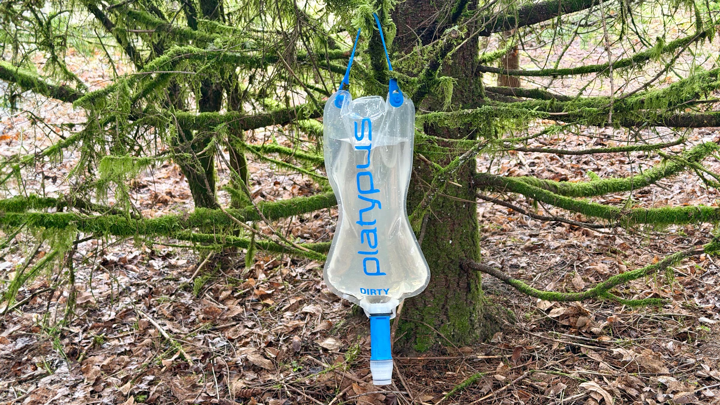 Platypus QuickDraw 3L Gravity Filter hangs from a tree while backpacking.