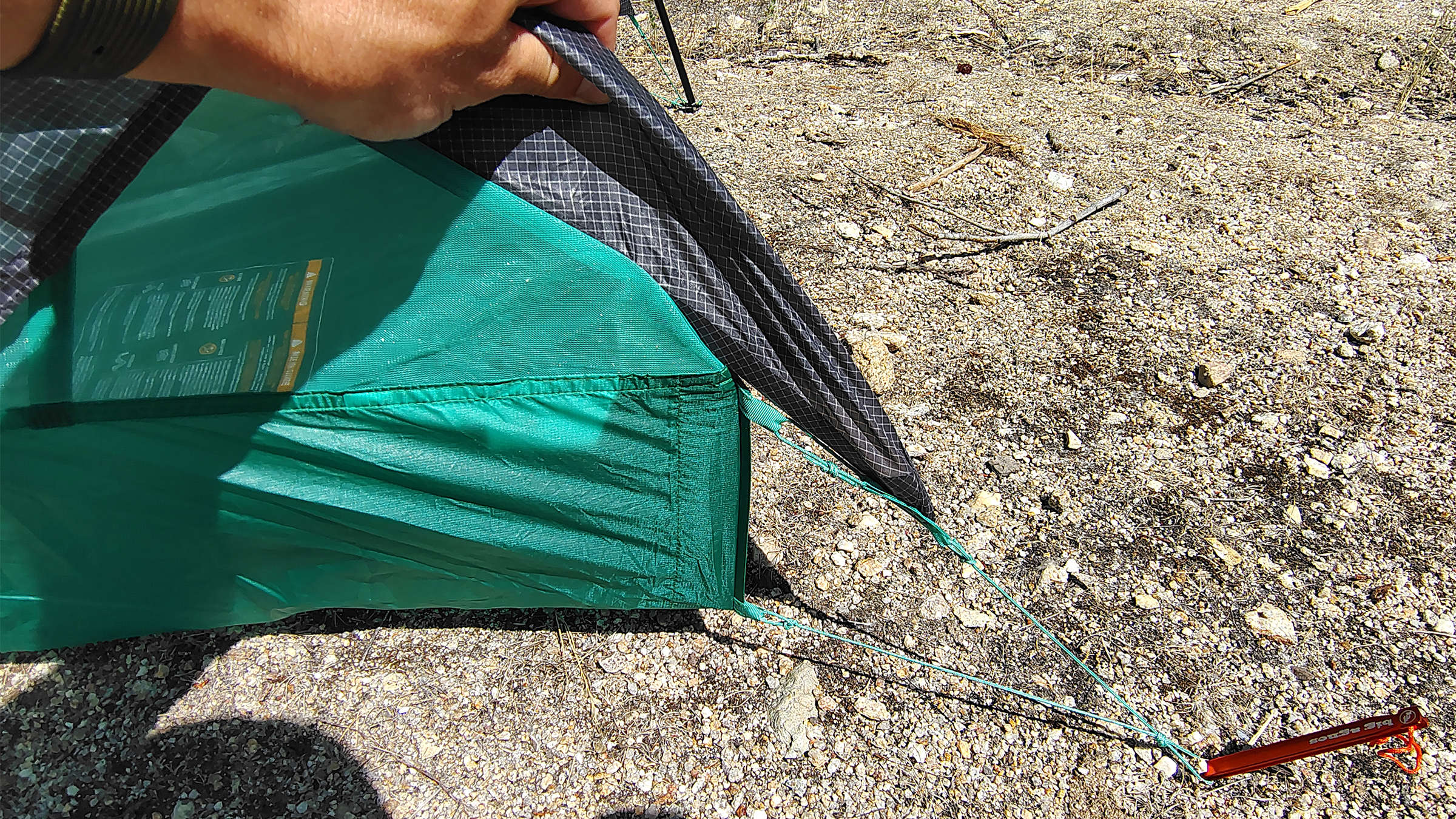 Big Agnes Pitchpine 1.5 being guyed out on a sandy campsite