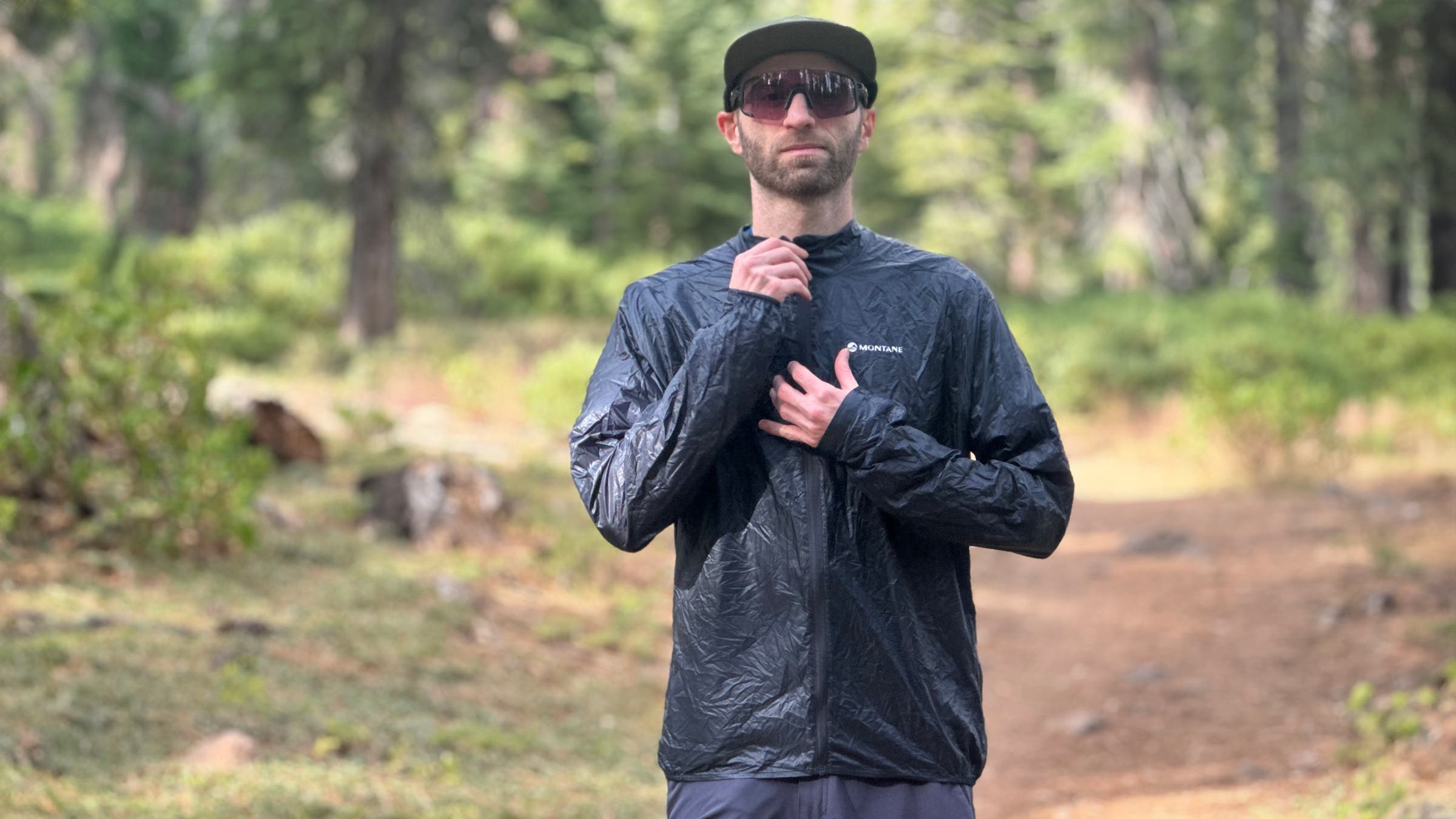 Montane Featherlite Nano tester zipping up jacket on hiking trail